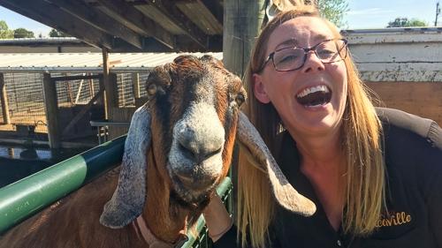 girl posing with a goat