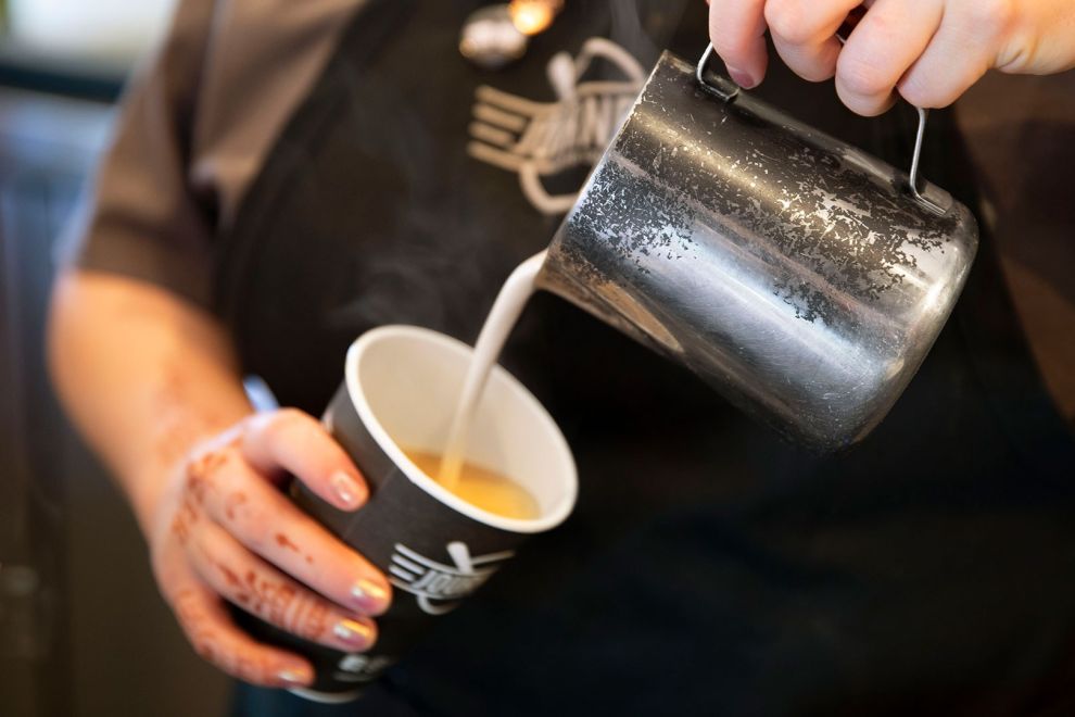 Pouring milk into a cup of coffee