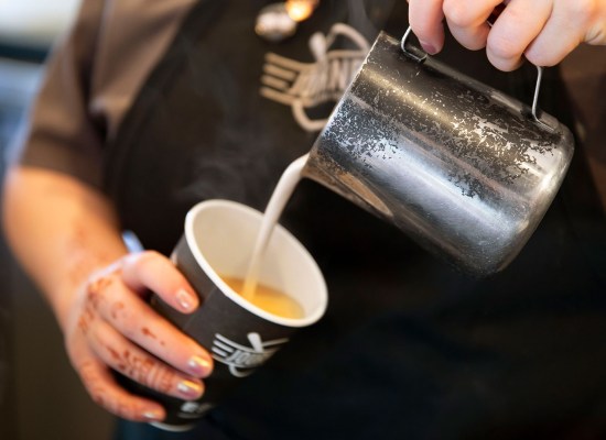 Pouring milk into a cup of coffee