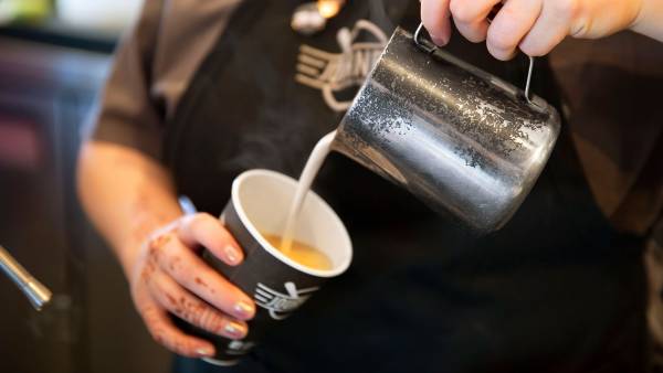 Pouring milk into a cup of coffee